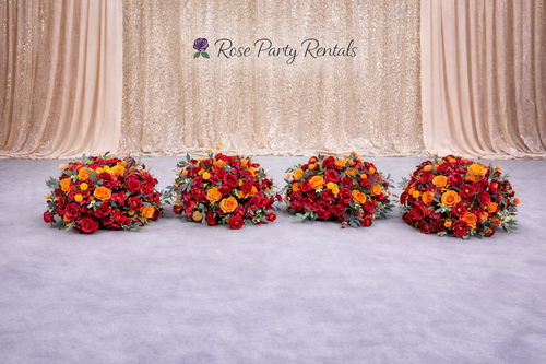Red and orange rose arrangements on champagne