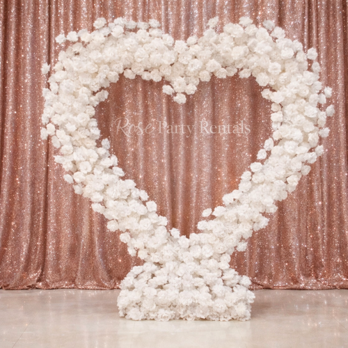 White floral heart arch on rose gold sequin backdrop
