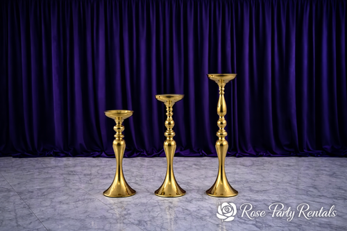 Gold classic candlestick pedestals on purple velvet