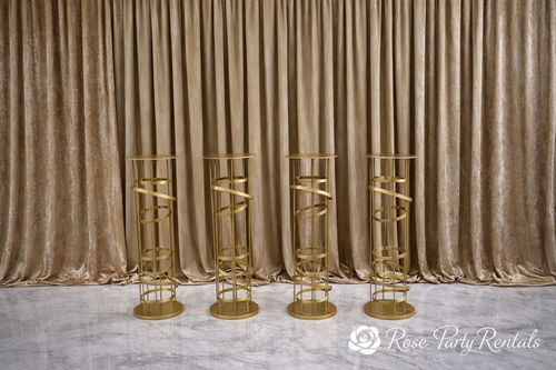 Gold spiral pedestal stands on blush drape