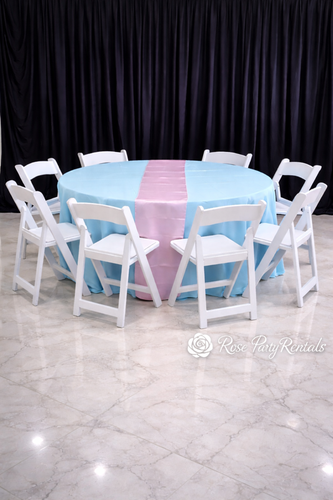 White folding chairs around round table with blue linen and pink runner